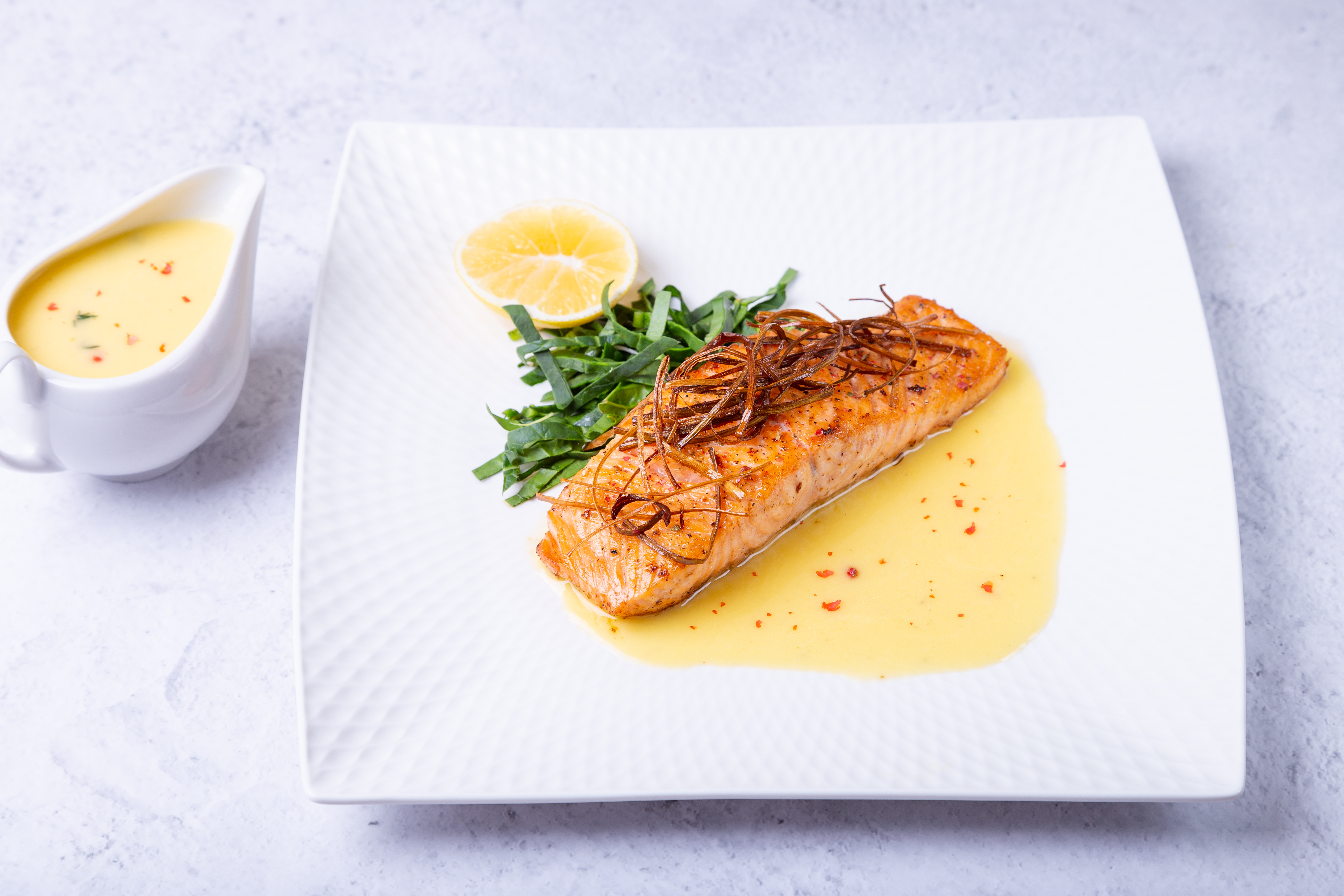 salmon-with-beurre-blanc-sauce-spinach-lemon-garnished-with-leeks-french-dish